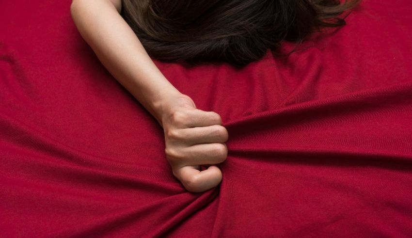 A woman's fist on a red blanket.
