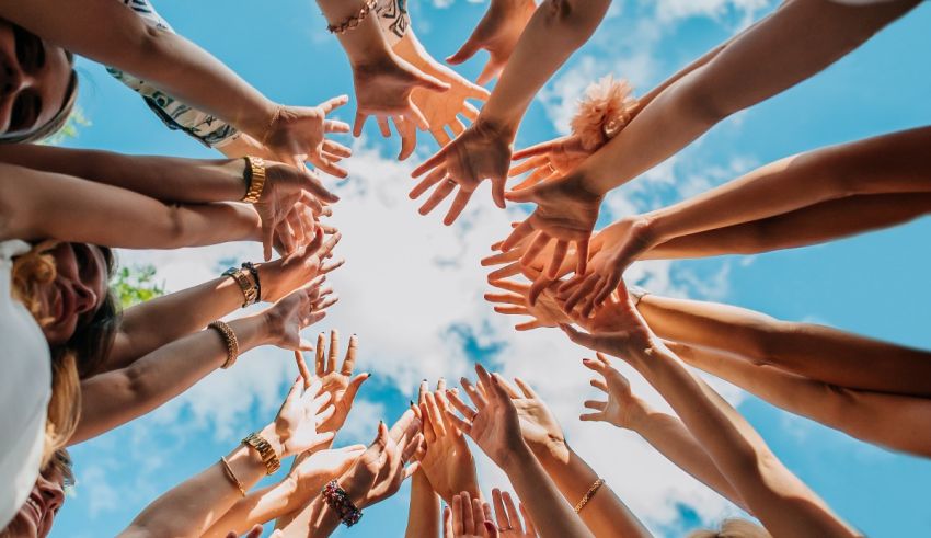 A group of people reaching their hands together in a circle.