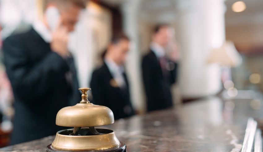 A group of people standing in front of a hotel bell.