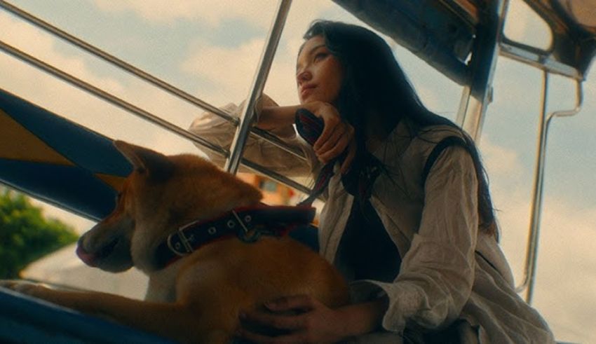 A woman sitting on a boat with a dog.