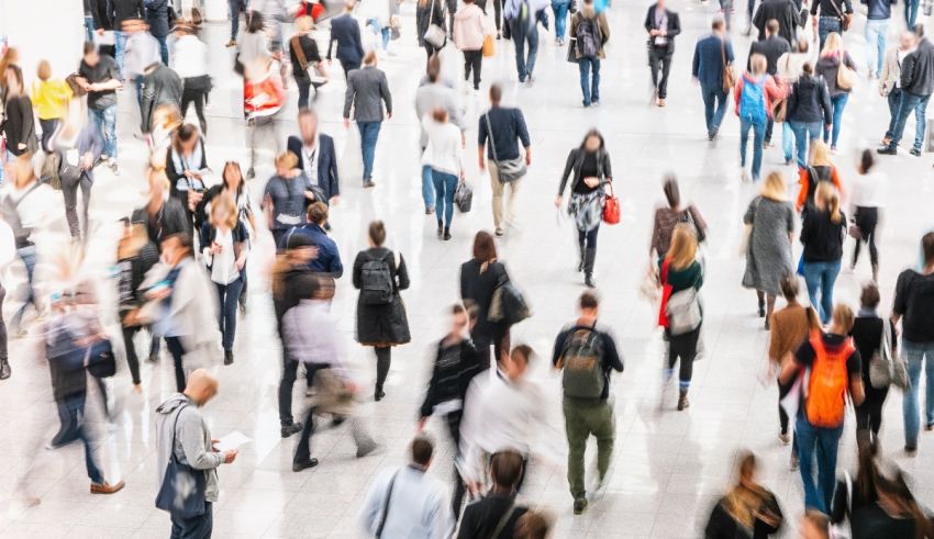 A blurry image of many people walking in a crowd.