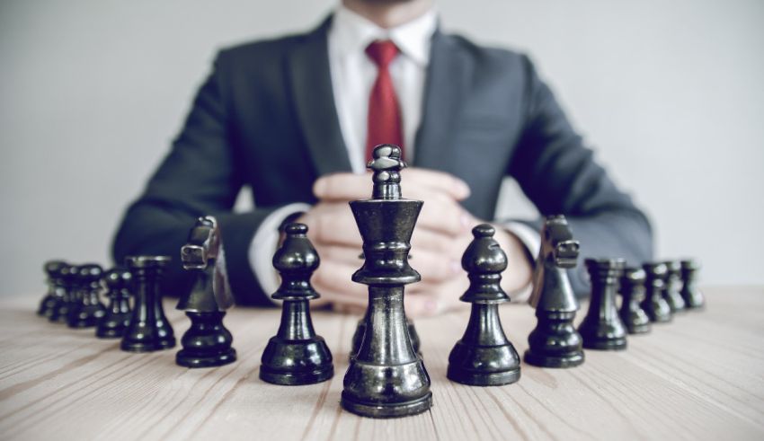 Businessman standing in front of chess pieces.