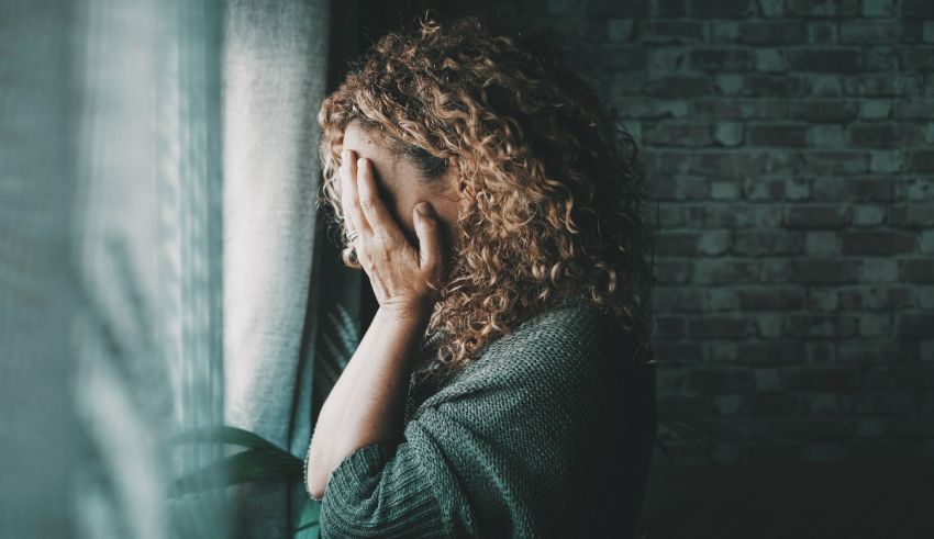 A woman with curly hair looking out a window.