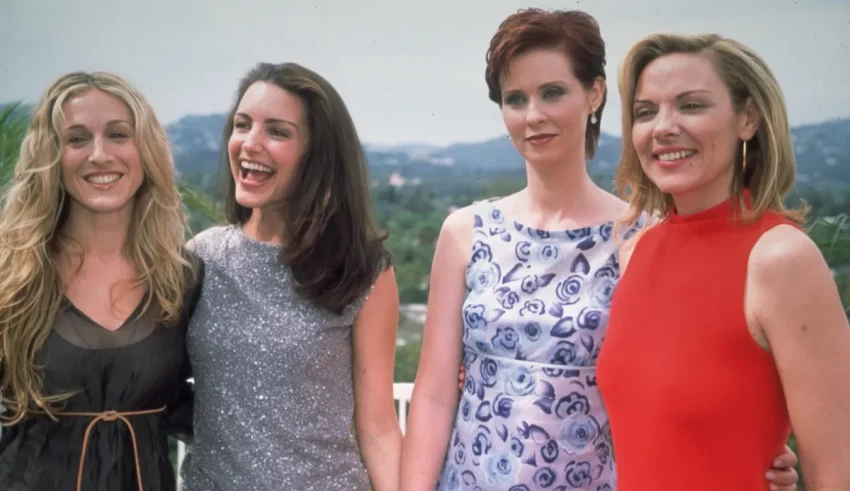 Four women are posing for a picture on a balcony.