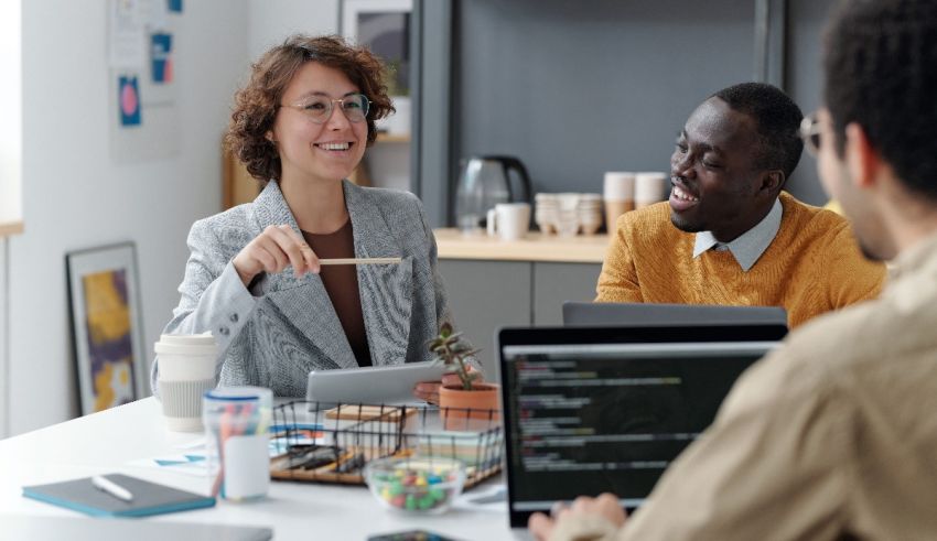 A group of people sitting around a table in an office.