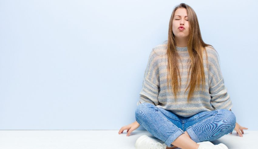 A young woman meditating on the floor.