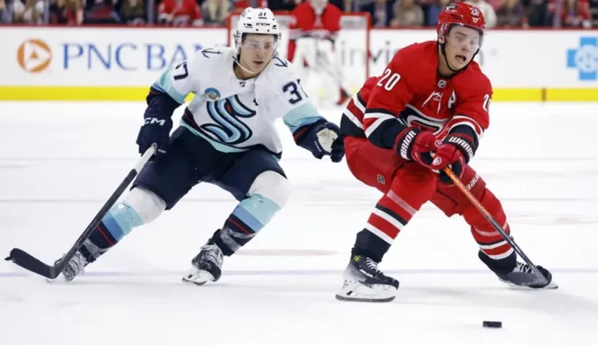 Two hockey players are playing a game on the ice.