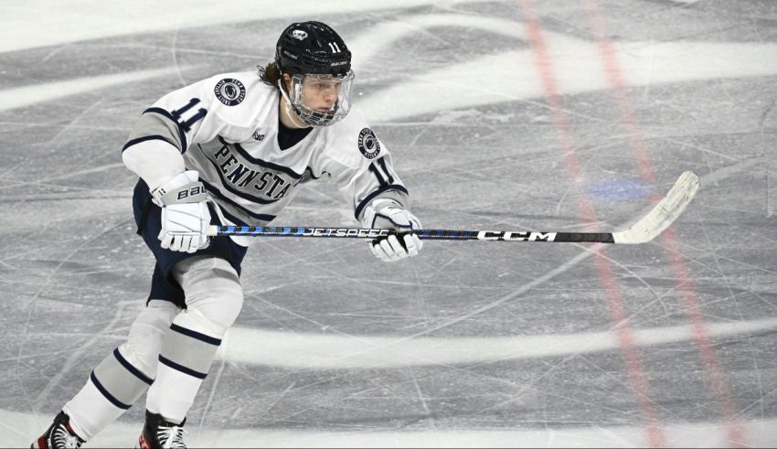 A hockey player is running with the puck on the ice.