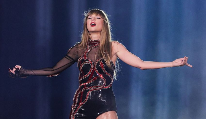 Taylor swift performs on stage with her arms outstretched.