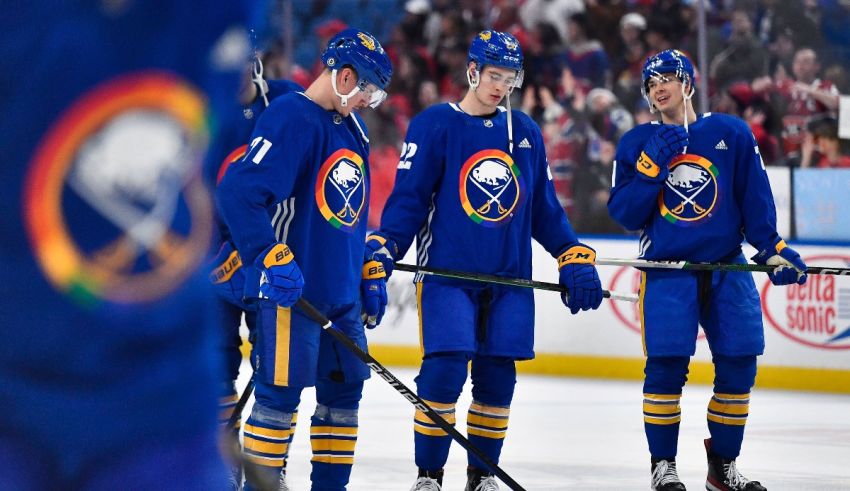 The buffalo sabres hockey players are standing on the ice.