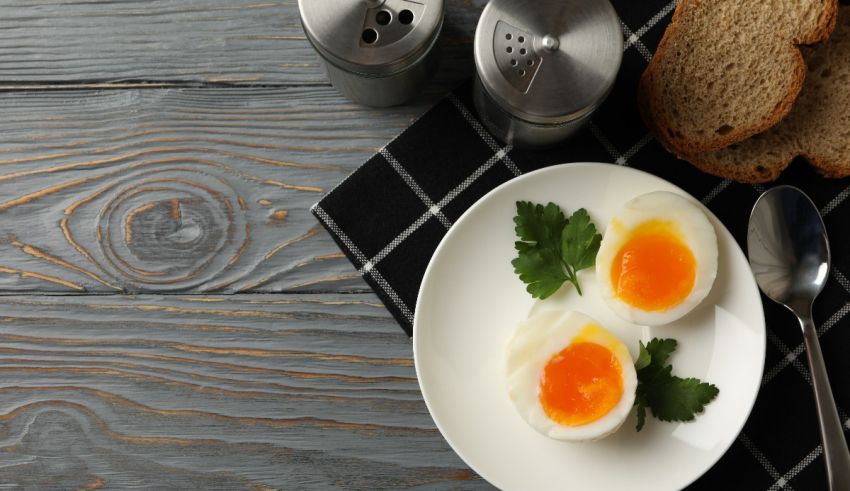 Hard boiled eggs on a plate on a wooden table.