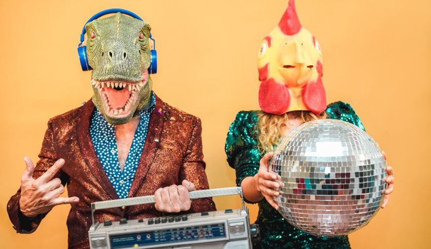 Two people dressed as a dinosaur and a t-rex holding a disco ball.