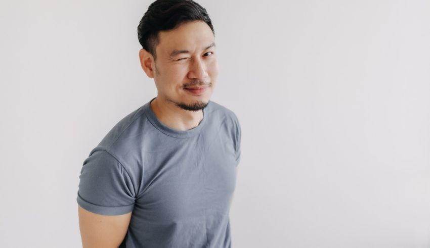 A young asian man wearing a gray t - shirt.