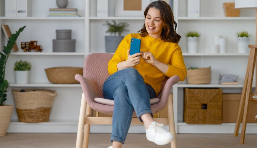 A woman sitting in a chair and using a mobile phone.