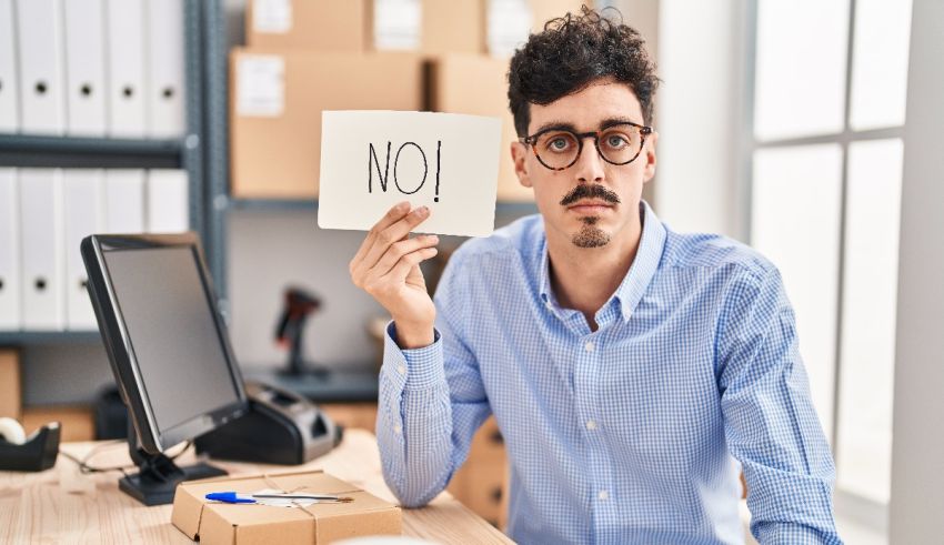 A man holding up a sign that says no.