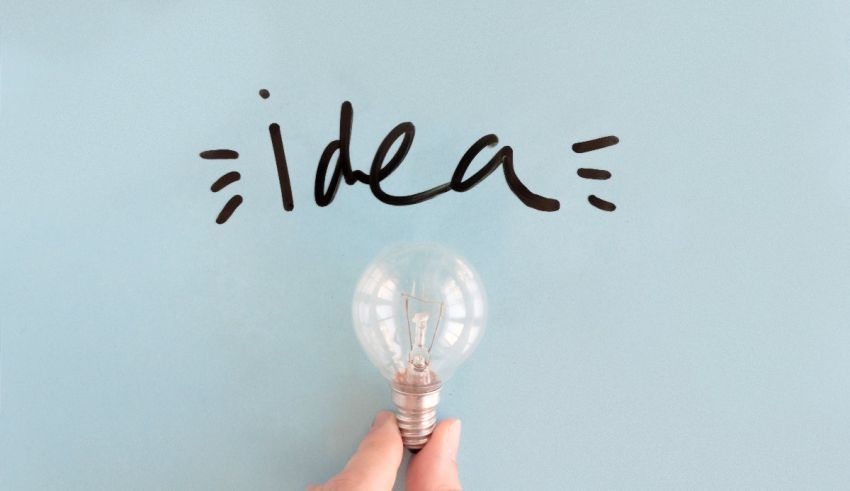 A hand holding a light bulb with the word idea written on it.