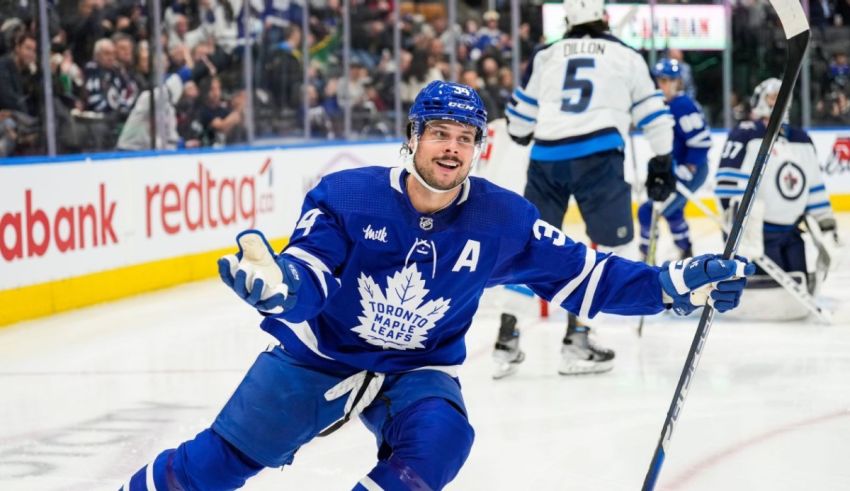 A toronto maple leafs player celebrates after scoring a goal.
