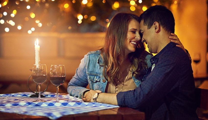 A man and woman hugging at a table in a restaurant.