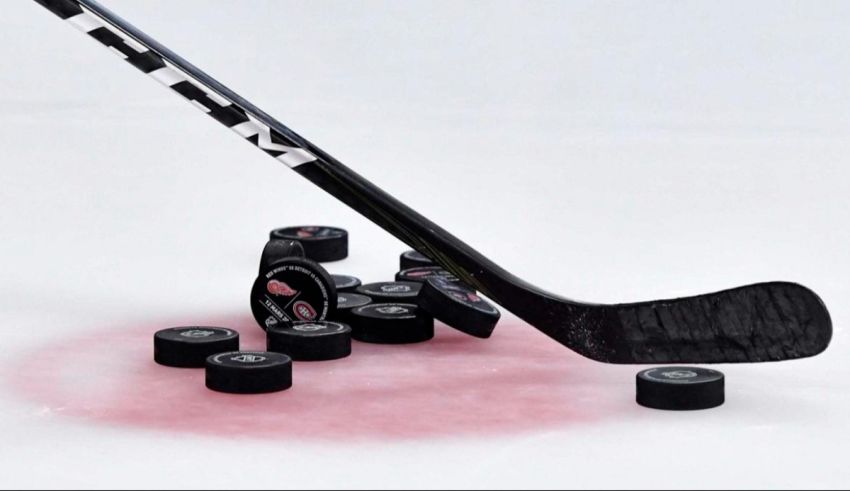 A hockey stick and puck on a white surface.