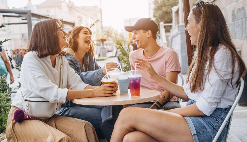 A group of friends sitting at an outdoor table and drinking drinks.