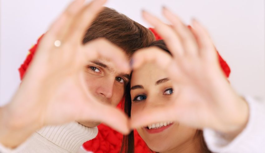A couple making a heart shape with their hands.