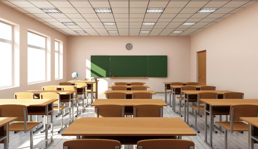 An empty classroom with wooden desks and a blackboard.