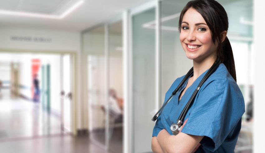 A female nurse standing in a hallway with her arms crossed.