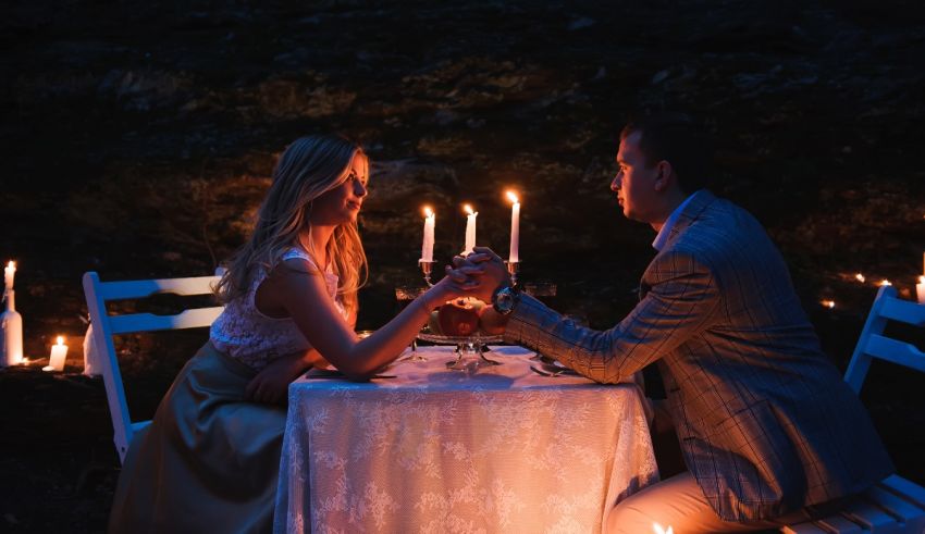A man and woman sitting at a table with candles.